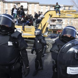 Agentes de Policía Municipal ante las personas subidas en una excavadora que trataban de evitar el desalojo de la vivienda en el número 29 de la calle Ofelia Nieto./ EFE-Javier Lizón