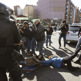 Agentes de Policía Municipal tratan de mover a varias de las personas que trataban de evitar el desalojo de la vivienda en el número 29 de la calle Ofelia Nieto./EFE-Javier Lizón