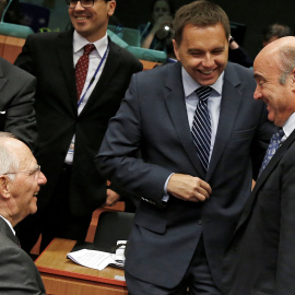 El ministro de Economía, Luis de Guindos, conversa con el titular alemán de Finanzas, Wolfgang Schaeuble, y el ministro eslovaco Peter Kazimir, antes de la reunión del Eurogrupo en Bruselas, el primer tras el nombramiento del nuego Gobierno