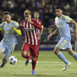 El delantero francés del Atlético de Madrid, Antoine Griezmann (c) lucha por el balón con Nemanja Maksimovic (i) del Astana. /EFE