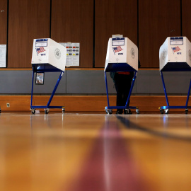 Varios votantes preparan su voto en las cabinas de un colegio electoral en el barrio neoyorquino de East Harlem. REUTERS/Andrew Kelly