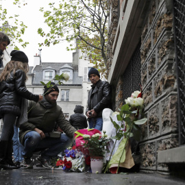 Varias personas dejan flores cerca del bar La Belle Equipe en París./ REUTERS