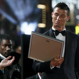 Cristiano al recibir un cuadro en la alfombra roja de la premiere de su película. /REUTERS