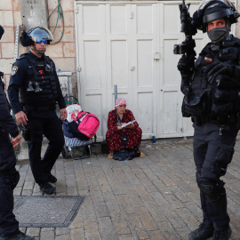  Una mujer toma notas ante la Policía de Israel en la puerta de Damasco en la ciudad de Jerusalén.- EFE/EPA/ATEF SAFADI