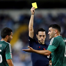 El árbitro Prieto Iglesias (c) muestra la tarjeta amarilla a Bruno González (d), del Betis en la pasada jornada de Liga. /EFE