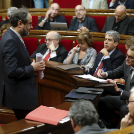 El cabeza de lista de la CUP, Antonio Baños, pasa junto al candidato de Junts pel Sí y president en funciones, Artur Mas, tras su intervención en el debate de la segunda votación de investidura tras las elecciones del 27-S. REUTERS/Albert G