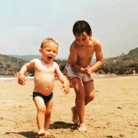 Michu, con 3 años, junto a su hermano Hernán en una playa de Asturias.