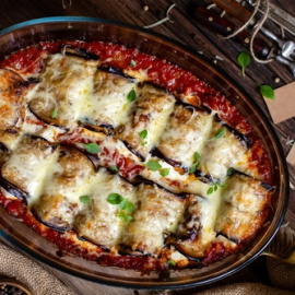 Rollitos de berenjena de jamón y queso con tomate frito.