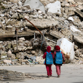 Niñas sirias camino del colegio en Alepo. / AFP