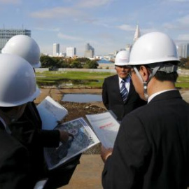 varios cargos del consejo de deportes de Japón miran un mapa del lugar donde se construirá el estadio para los Juegos Olímpicos de 2020.- REUTERS