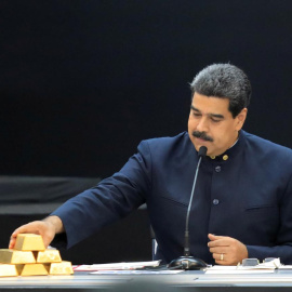Nicolás Maduro toca unos lingotes de oro, en una reunión con ministros del área económica, en el Palacio de Miraflores (Caracas), en marzo de 2018. REUTERS/Marco Bello