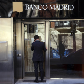 Un hombre delante de una oficina de Banco Madrid. REUTERS