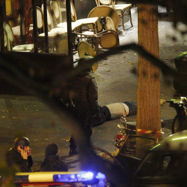 Agentes de la Policía francesa junto a una de las víctimas del ataque terrorista a la sala de conciertos Bataclán, en París, el pasado viernes. . EFE/EPA/YOAN VALAT