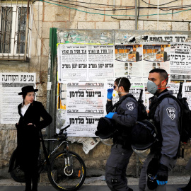 Policías israelíes con mascarillas patrullan por el bario de judios ultra-ortodoxos de Mea Shearim, en la zona norte de Jerusalén. REUTERS/Ronen Zvulun
