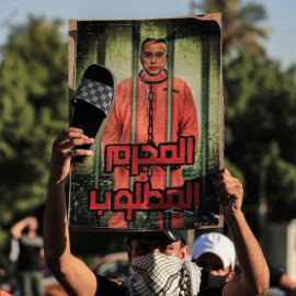  6 de noviembre de 2021, Iraq, Bagdad: un hombre sostiene un cartel del primer ministro iraquí Mustafa Al-Kadhimi, en el que se lee "Se busca criminal" durante un acto de duelo frente a una de las puertas de la Zona Verde de Bagdad.- Ameer 