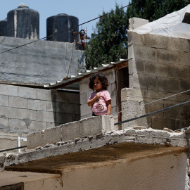 Una niña se de pie ante un edificio dañado luego de una operación militar israelí en el campo de refugiados de Yenin, en Cisjordania ocupada por Israel el 8 de julio de 2023. -RANEEN SAWAFTA / Reuters