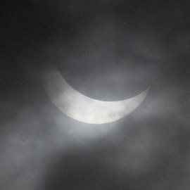 El eclipse parcial de sol a través de las nuves en Dunte. REUTERS/Ints Kalnins