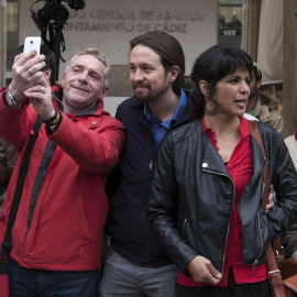 El líder de Podemos, Pablo Iglesias, con la candidata de Podemos Teresa Rodríguez, posa con un hombre para un selfi. EFE/Román Ríos