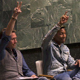 El músico Pharrell Williams, con el investigador medioambiental Phillipe Cousteau Jr., hacen el gesto de la vicotria en la Asamblea General de la ONU.. REUTERS/Mike Segar