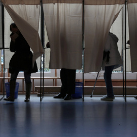 Varias personas en las cabinas dispuestas en los centros electorales preparan su voto para las elecciones locales francesas en Niza./ REUTERS-Eric Gaillard