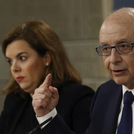 La vicepresidenta del Gobierno, Soraya Sáenz de Santamaría, junto al ministro de Hacienda y Administraciones Públicas, Cristóbal Montoro, durante la conferencia de prensa posterior al Consejo de Ministros, hoy en el Palacio de la Moncloa. E