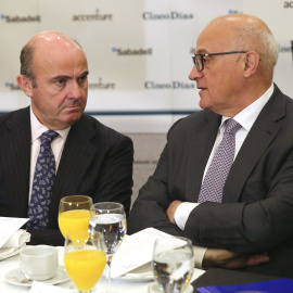 El ministro de Economía, Luis de Guindos, conversa con el presidente de Banco Sabadell, Josep Oliu, antes de intervenir en el Foro Cinco Días. EFE/Ballesteros