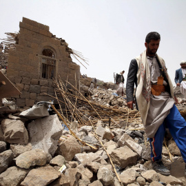 Un hombre entre los escombros de una casa derruida por un bombardeo en el pueblo de Okash, cerca de Saná. - REUTERS