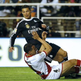 El delantero portugués del Real Madrid, Cristiano Ronaldo (arrriba), cae ante el defensa del Rayo Vallecano, Amaya. /EFE