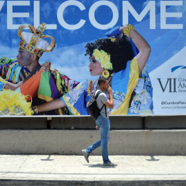 Un hombre pasa junto a un cartel de la Cumbre de las Américas que se celebrará en Ciudad de Panamás el 10 y 11 de abril. - AFP