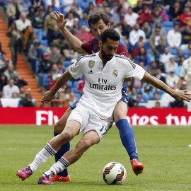 El defensa del Real Madrid Álvaro Arbeloa (primer término) con el balón ante la oposición del (c), durante el partido de la trigésima primera jornada de liga de Primera División disputado esta tarde en el estadio Santiago Bernabéu./EFE