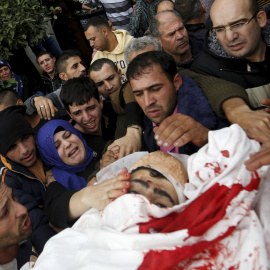 Familiares del joven palestino Yehia Taha, asesinado por las tropas israelíes, según dijeron los médicos, durante disturbios en la aldea cisjordana de Qatnna.- REUTERS/Mohamad Torokman