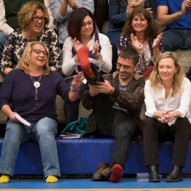 El cofundador de Podemos Juan Carlos Monedero, en presencia de la cabeza de lista al Congreso por Las Palmas, la juez Victoria Rosell (d), y la secretaria general de Canarias, Meri Pita (i), muestra sus calcetines después de que un asisiten