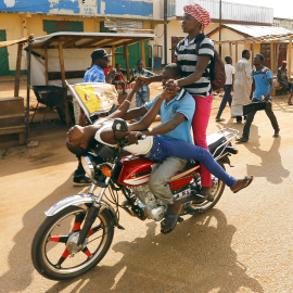 Unos africanos montan en una moto, cerca de la mezquita de Koudoukou  donde se encontraba el Papa Francisco. Bangui, República Centroafricana. REUTERS/Stefano Rellandini