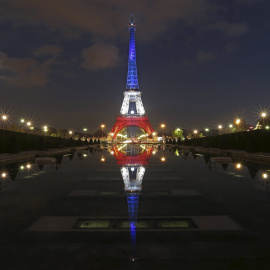 La Torre Eiffel encendida con los colores de la bandera francesa tras los atentados de París. REUTERS/Christian Hartmann