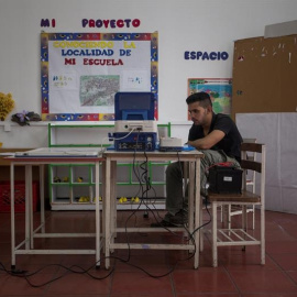 Un miembro de mesa electoral trabaja en una máquina de votación durante los preparativos para las elecciones. EFE/MIGUEL GUTIERREZ