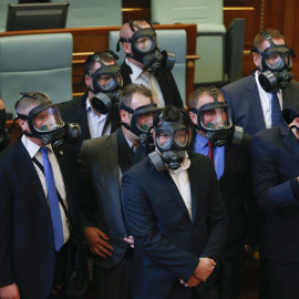 Diputados utilizan máscaras antigás después de que miembros de la oposición lanzaran gas lacrimógeno durante una sesión parlamentaria en Pristina, Kosovo. EFE/Valdrin Xhemaj