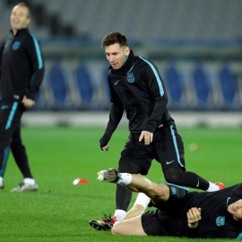 El delantero argentino del FC Barcelona, Lionel Messi (c) y su compañero, el croata Ivan Rakitic (abajo), participan en un entrenamiento del equipo en el Estadio Internacional de Yokohama. /EFE