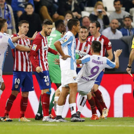 Jugadores del Málaga y el Atlético de Madrid, discuten en presencia del colegiado, Mateu Lahoz.EFE/Jorge Zapata.