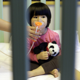 Una niña de dos años recibe es asistida en un hospital tres días después de que la capital china emitiese su segunda "alerta roja" por la contaminación del aire, en el Hospital de New Century International Children, en Beijing, China. REUTE