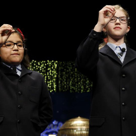 Las niñas de San Ildefonso Lorena Stefan y Nicol Valenzuela muestran las bolas del número 79.140 que ha sido agraciado con el Gordo de Navidad, dotado con cuatro millones de euros por serie (400.000 euros por décimo), en el Sorteo Extraordi