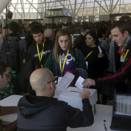 Vista a través de un cristal de los participantes en la votación realizada durante la asamblea de la CUP sobre la investidura de Artur Mas. EFE/Alberto Estévez