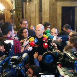 El cabeza de lista de Junts pel Sí (JxSí), Raül Romeva, rodeado de periodistas en los pasillos del Parlament. E.P.