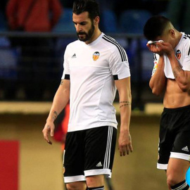El delantero del Valencia Álvaro Negredo (i) abandona desolado el terreno de juego tras perder contra el Villarreal. EFE