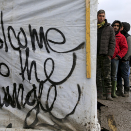 Los inmigrantes hacen cola para recibir ropa en el campamento provisional para refugiados de procedentes de Irak, Kurdistán, Irán y Siria, cerca de Dunkerque (Francia). REUTERS / Pascal Rossignol