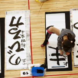 Una niña participa en un concurso de caligrafía para celebrar el Año Nuevo en Tokio. REUTERS/Thomas Peter