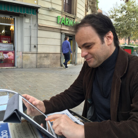 Jaume Asens consulta su iPad en un chaflán de Barcelona.