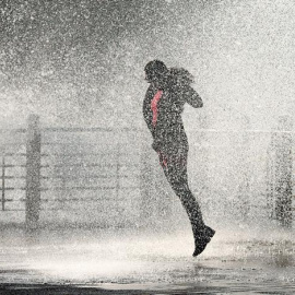 Una joven es alcanzada por una gran ola que rompe contra el Paseo Nuevo de San Sebastián, en el País Vasco. EFE/Juan Herrero