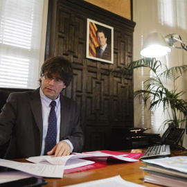 El nuevo presidente electo catalán, Carles Puigdemont, en su despacho del Ayuntamiento de Girona tras hacer oficial su renuncia a la alcaldía de la ciudad. EFE/David Borrat