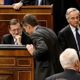 El diputado popular por Segovia Pedro Gómez de la Serna (d), excluido del grupo por sus negocios en el extranjero, pasa al lado del presidente del Gobierno en funciones, Mariano Rajoy, durante la sesión constitutiva del Congreso que da paso
