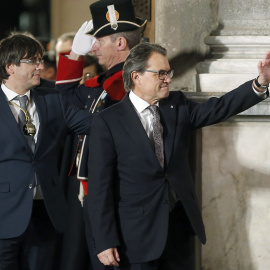 El expresidente de la Generalitat, Artur Mas, abandona el Palau de la Generalitat acompañado del nuevo presidente, Carles Puigdemont tras el acto de toma de posesión. EFE/Andreu Dalmau